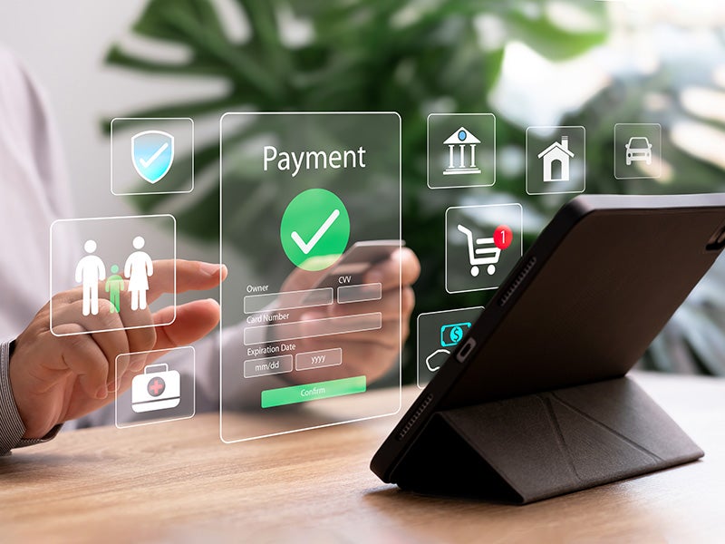 A person using a tablet for secure online payment with floating virtual payment screens